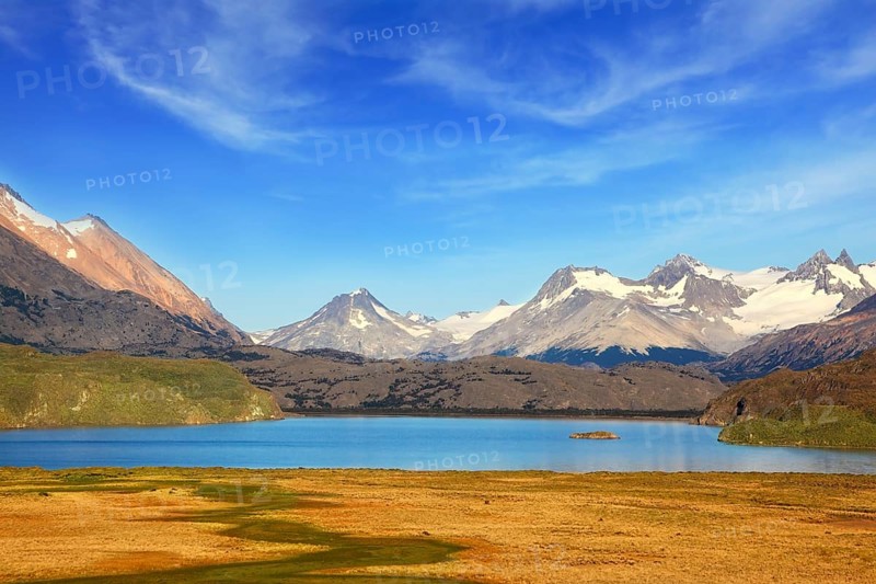 A blue lake in a picturesque valley surrounded by snow-capped mountains. National Park Perito Moreno in Patagonia, Argentina