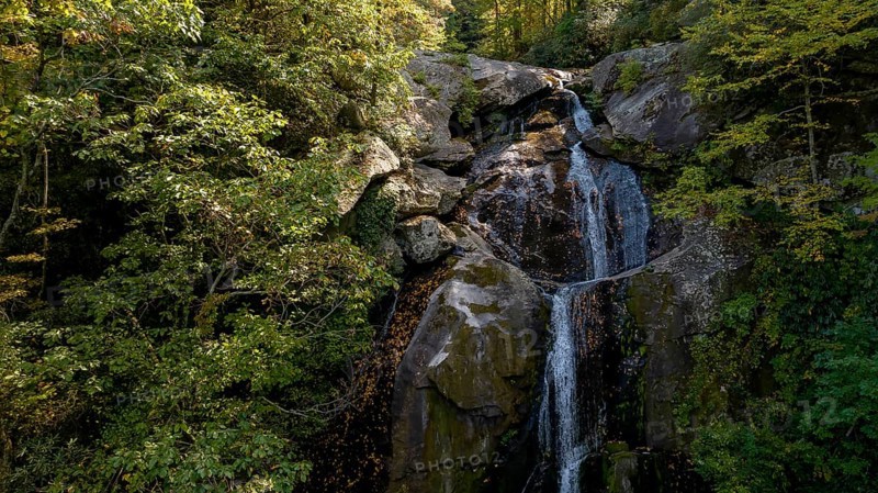 A beautiful waterfalls set in a mountain environment as the leaves start changing for fall