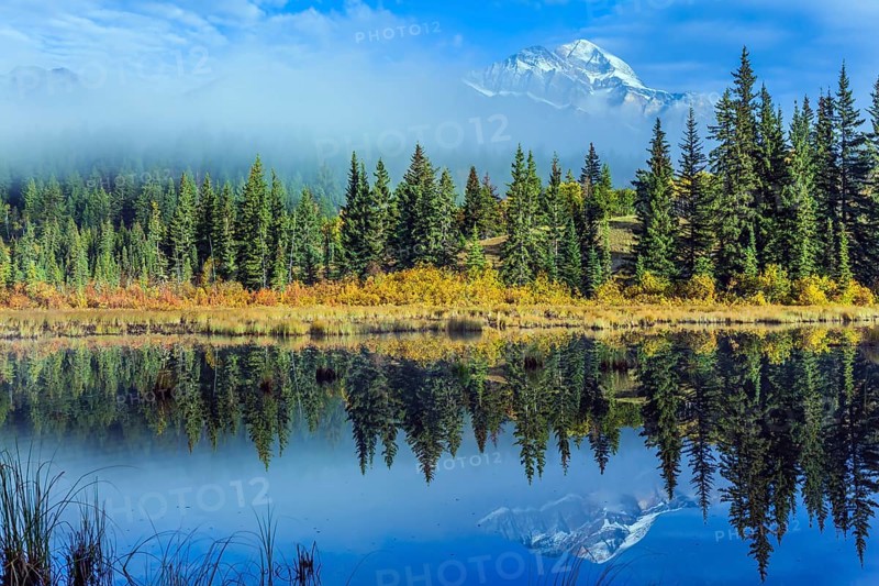 Wonderful landscape. The blue water of the Patricia Lake reflects the snowy peak of the Pyramid Mountain. The concept of active, ecological and photo tourism