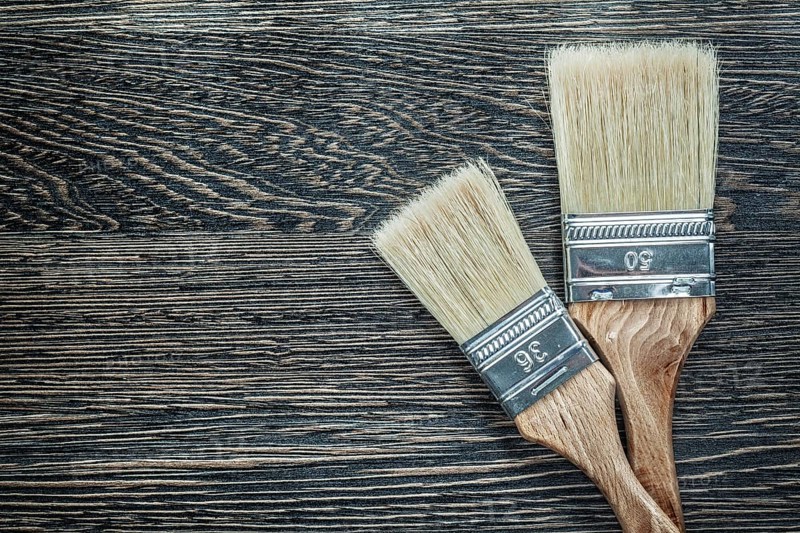 Paintbrushes on wooden board top view