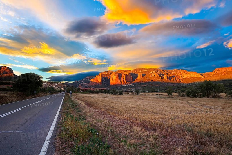 Red sunset. The magnificent Mallets of Riglos cliffs. Scenic paved highway. Romantic trip to Spain. Province of Huesca, Aragon. Mallets of Riglos is a conglomerate of rock formations
