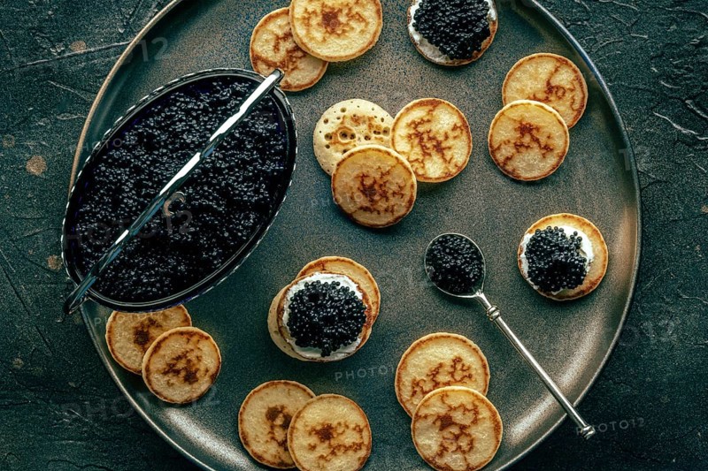 Blinis with caviar, overhead flat lay shot on a festive dish, mini pancakes, an elegant appetizer, Food photography, Food photography