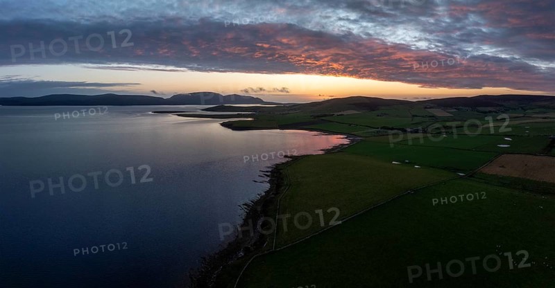 Sunset with cloud band on the coast of Scapa Flow with view to the island of Hoy, drone shot, Orphir, Orkney, Scotland, Great Britain