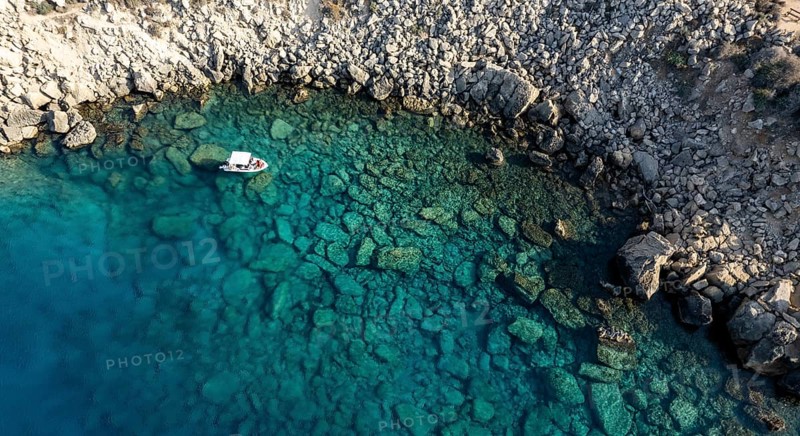 Drone aerial seascape with luxury yacht moored on the coast. Blue water Summer vacations in the sea. Cape Greko Cyprus