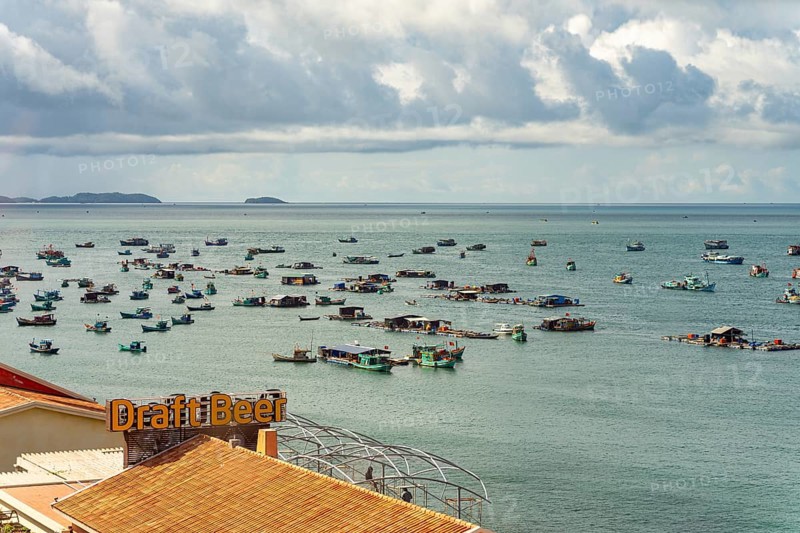 Calm sea with scattered boats and a cloudy sky in a coastal setting, palms, city, sun city, Phu Quoc, Vietnam
