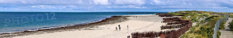 Panoramic photo north beach Helgoland dune with tourist hiker and wooden dune path, island Helgoland, Schleswig-Holstein, Germany