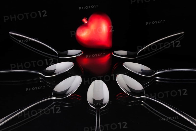 Teaspoons and love symbol on the black glass desk
