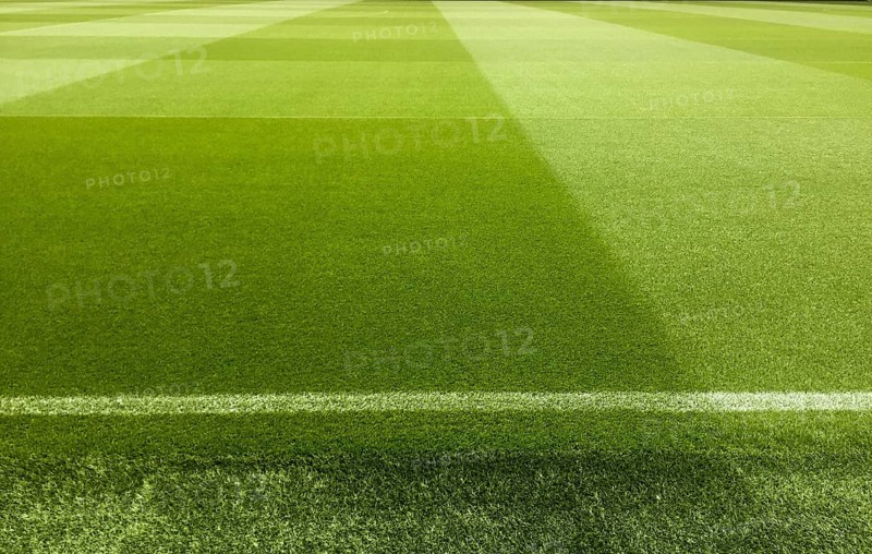 An empty football stadium with green grass