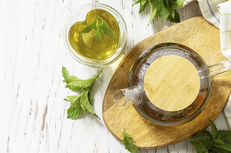 Cup and teapot of fresh natural herbal tea with fresh mint leaves on rustic wooden table. Organic aromatherapy relaxation medical healthy drink. View from above. Copy space
