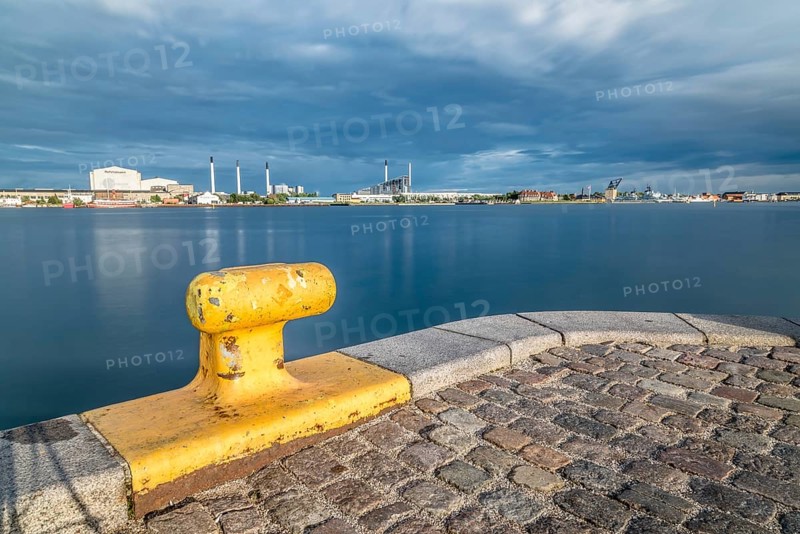 Scenic view of the skyline of Copenhagen at sunset from dock with yellow bollard on foreground
