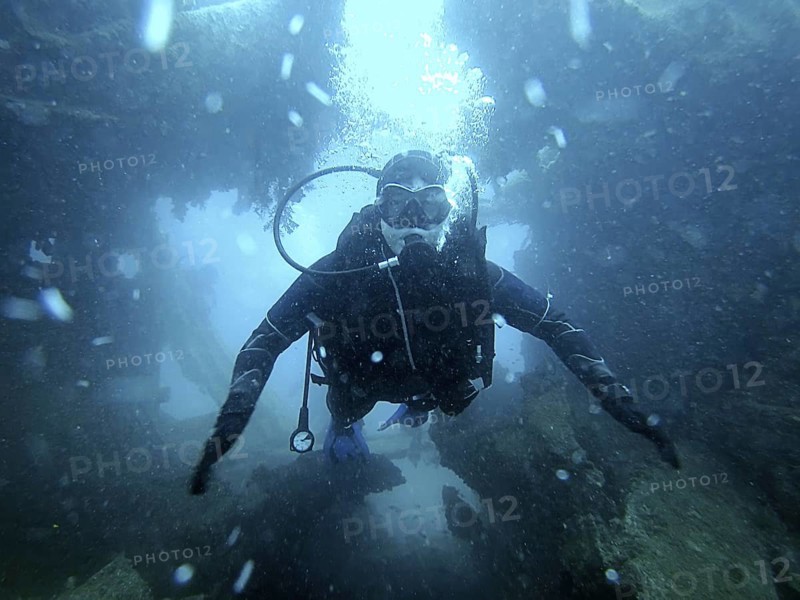 Scuba diver exploring the inside underwater shipwreck