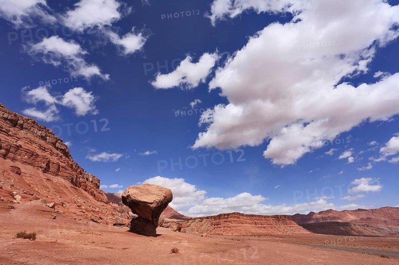 American rock desert. The famous giant mushroom of red sandstone, glowing clouds, midday shadows