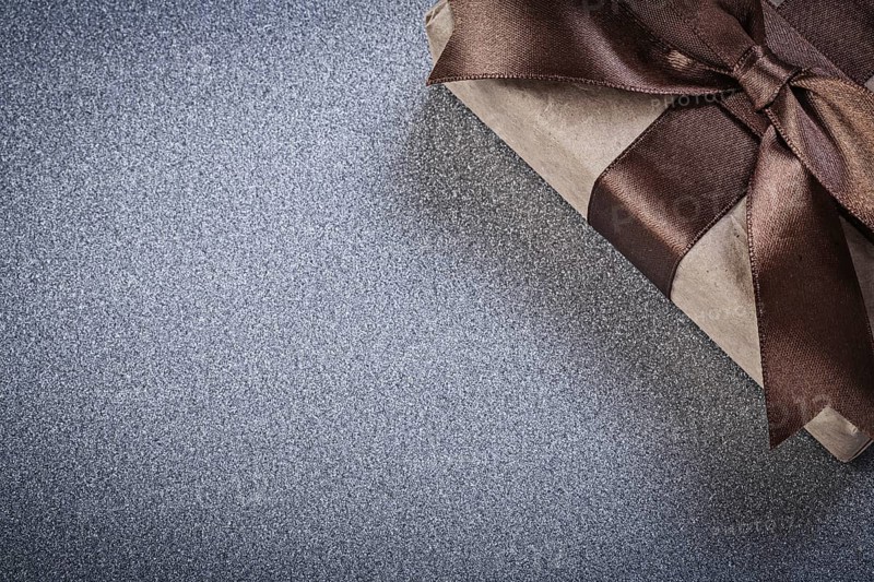 Packaged present with brown bow on grey background celebrations concept