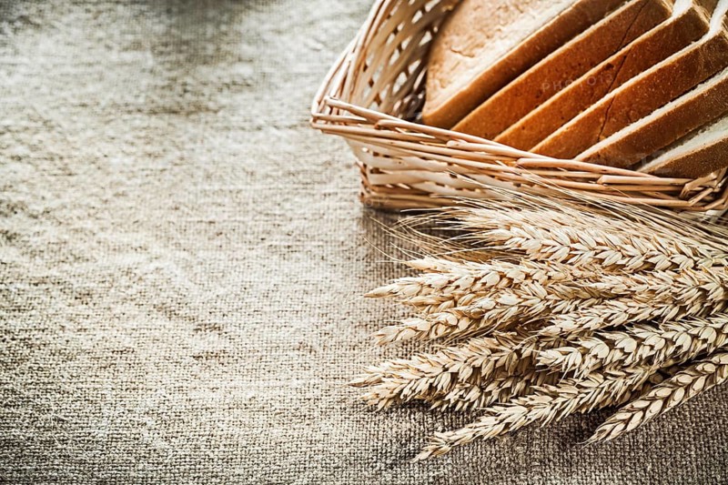 Wicker basket sliced toast bread rye ears on textured sacking background
