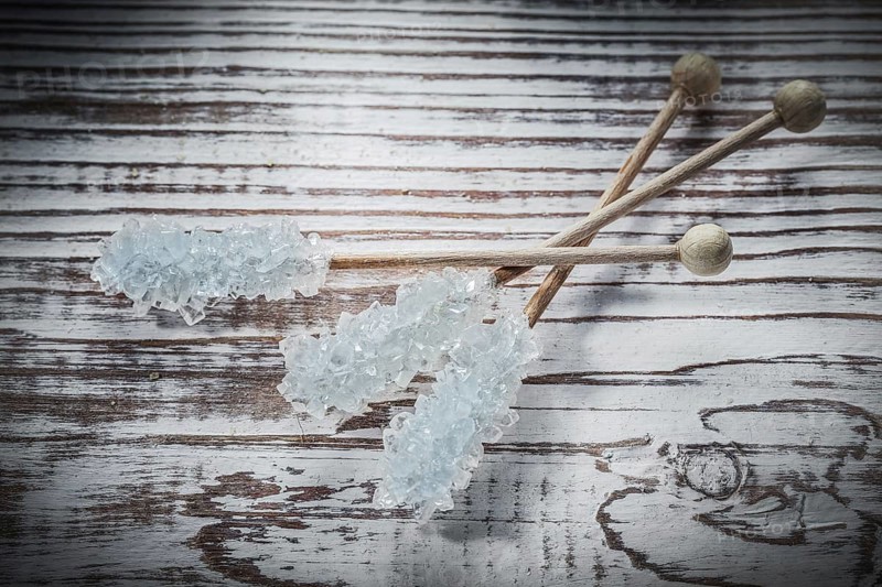 Sweet sugar sticks on vintage wooden board