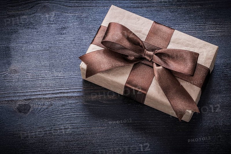 Gift box-container with bow on vintage wooden board