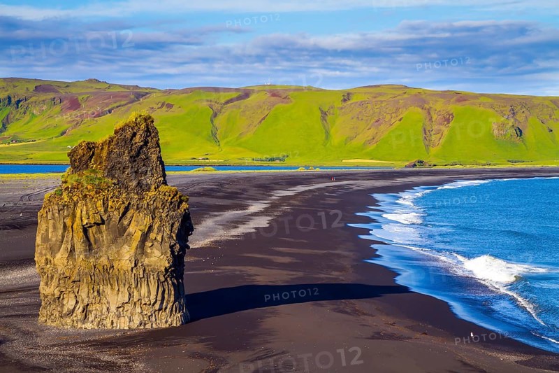 Cape Dyrholaey. Travel to the fabulous island of Iceland. Giant lonely rock - Palm on a black volcanic sand beach Reinisfjara. The concept of active, extreme and photo tourism