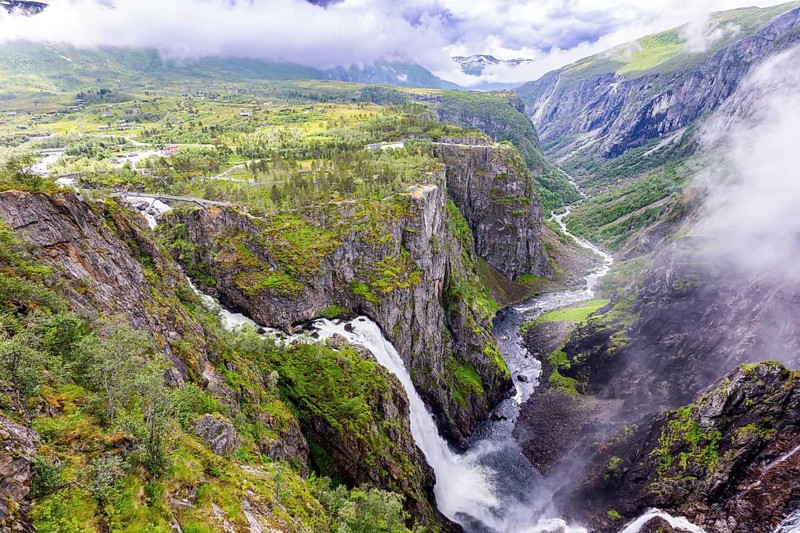 Voringsfossen is a majestic waterfall on the Hardangerfjord. The waterfall falls into a narrow deep picturesque gorge. Rainy cold July in Norway