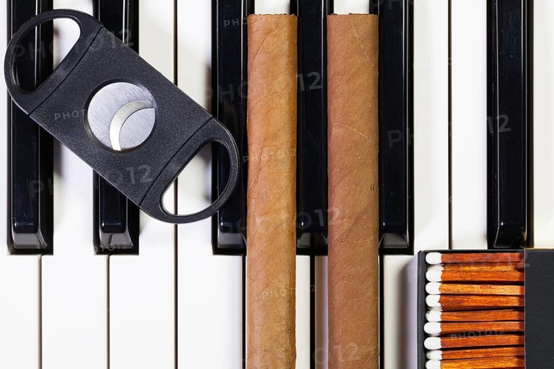 Detail of piano keyboard and luxury cigars