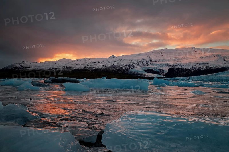 Ice floes on the black sea sand and the coast Fjallsarlon lagoon