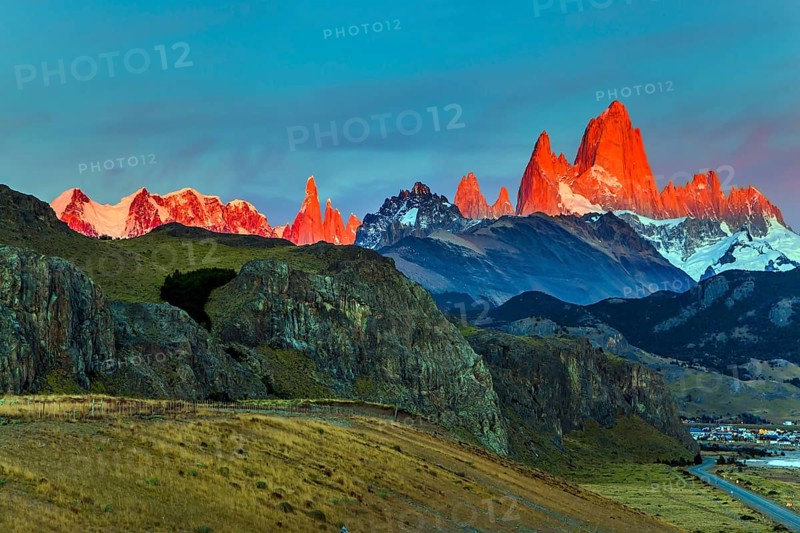 The grand crimson dawn over the mountain range Fitzroy. Mountain peak in Patagonia in the border area between Argentina and Chile. Magnificent and picturesque mountain range, illuminated by the sunrise sun. The concept of extreme, active and photo tourism