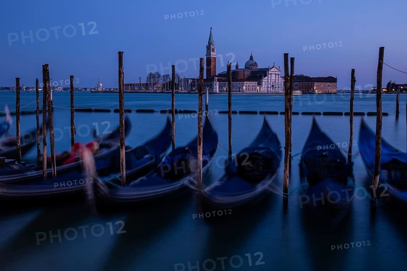 Venetian gondolas, boat dock at St Mark's Square, church of San Giorgio Maggiore in the background, blue hour, long exposure, Venice, Veneto, Italy