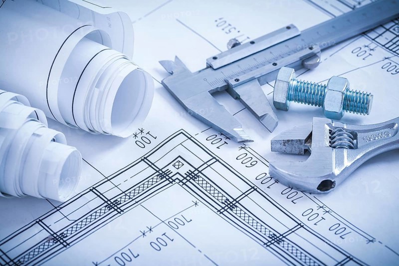 Screw bolt with nut adjustable spanner slide caliper rolls of construction plans on blueprint architecture and building concept