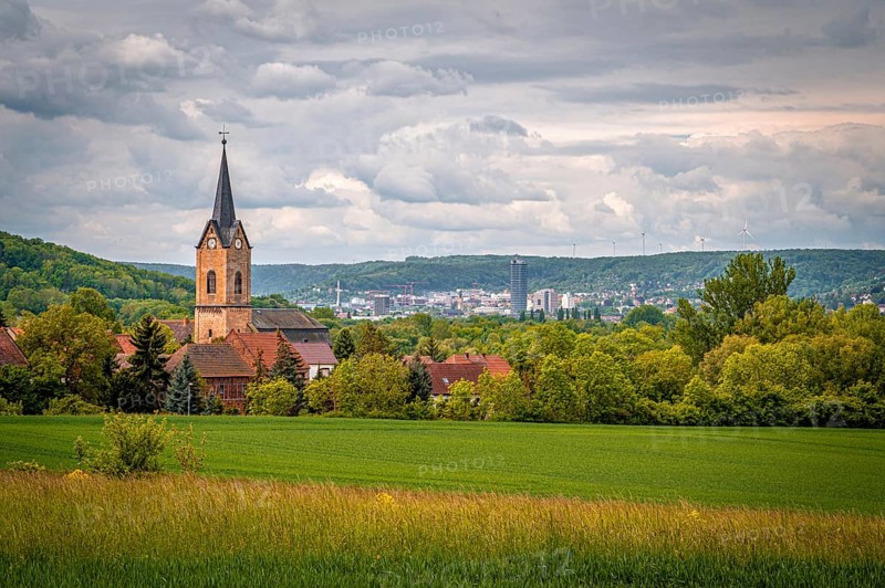 Church of Kunitz in the middle of a rural landscape with a view of the city of Jena, under a cloudy sky, Kunitz, Thuringia, Germany