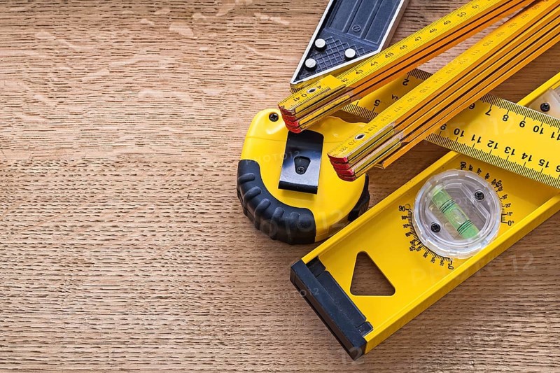 Wood oaken board with yellow objects of measurement construction concept