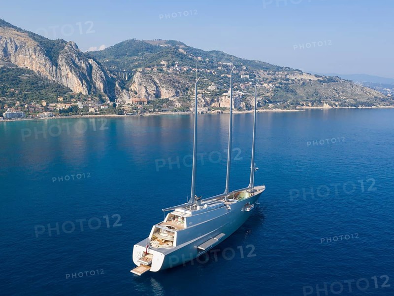 Aerial view 143 metre long three-master Sailing Yacht A, the largest sailing yacht in the world, built to a design by designer Philippe Starck by the German shipyard Nobiskrug and delivered in 2017 to the Russian oligarch Andrei Melnichenko, Andrey Melnichenko, over 100 metre high carbon masts, at anchor off Menton, Cote d'Azur, Mediterranean Sea