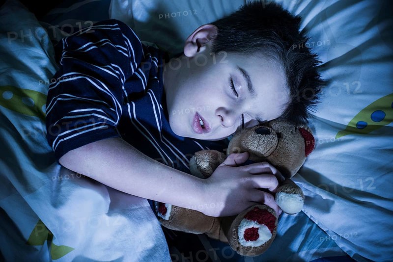 Sleeping child with his toy bear