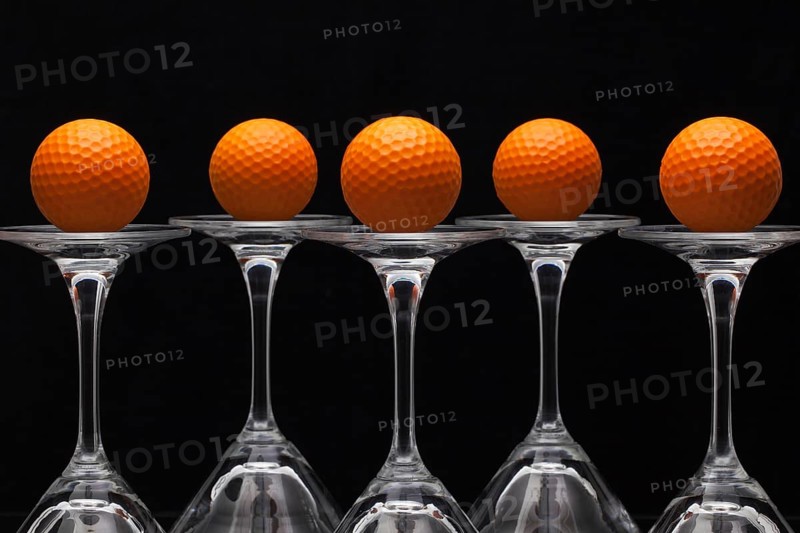 Five glasses of champagne with golf balls