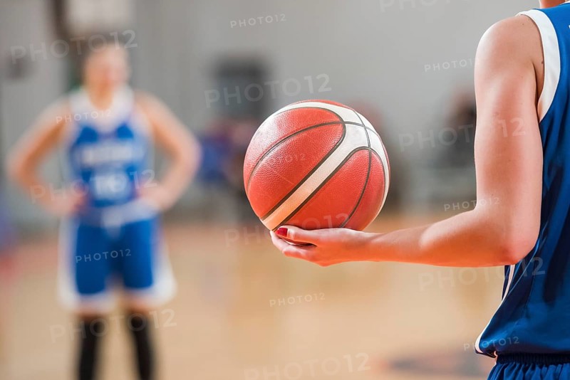 Basketball player keeps ball during basketball match
