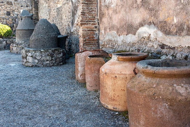 POMPEII, ITALY, MAY 04, 2022, Big clay amphoras buried into the soil of an ancient Pompeian warehouse, Southern Italy