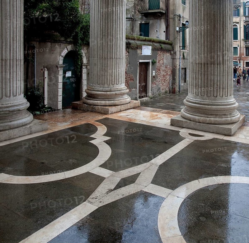 Italy Venice Church of San Nicolò da Tolentino -13 built 1704-16 by Andrea Triali Colonnaded porch with baroque marble and granite inlaid stone floor in the rain