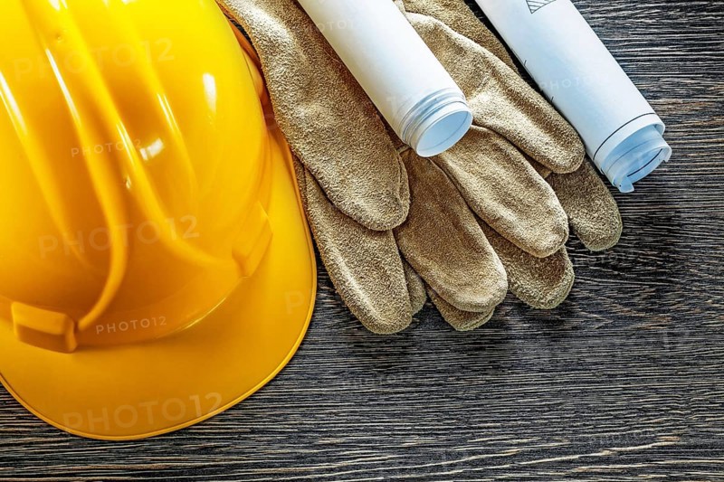 Leather protective gloves construction plans hard hat on wooden board
