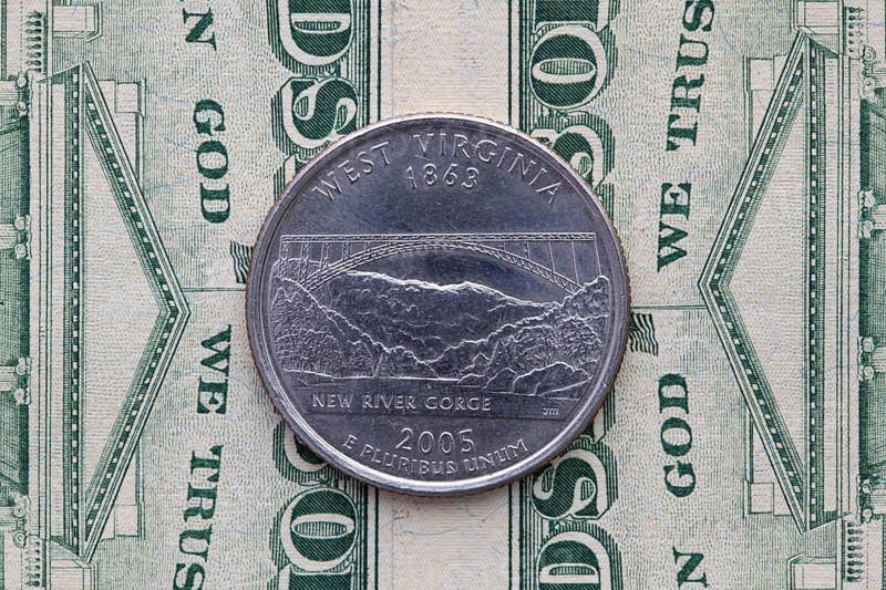 A quarter of West Virginia on US dollar bills. Symmetric composition of US dollar bills and a quarter of West Virginia