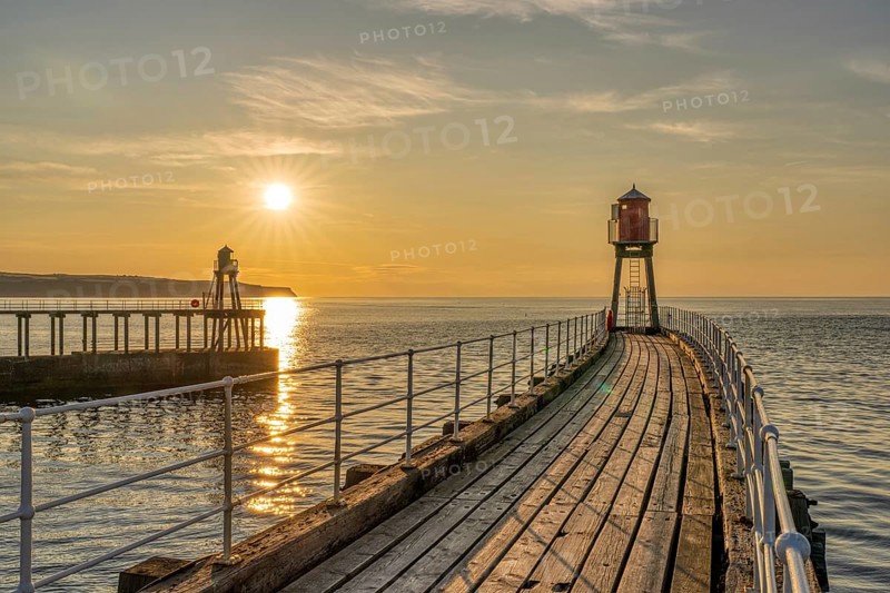 Sunset at the West and East Pier in Whitby, North Yorkshire, England, UK