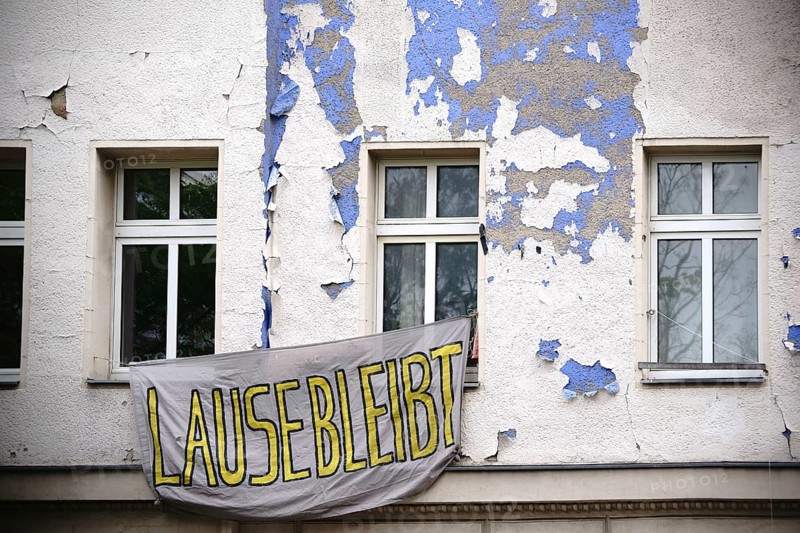A sheet with a slogan hangs in front of a squatted flat in an old building in Berlin Kreuzberg