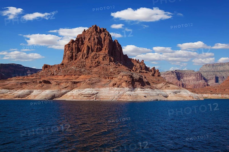 Scenic huge artificial pond Powell on the Colorado River, USA. The lake is surrounded by picturesque banks of orange sandstone. Walk around the lake Powell at sunset