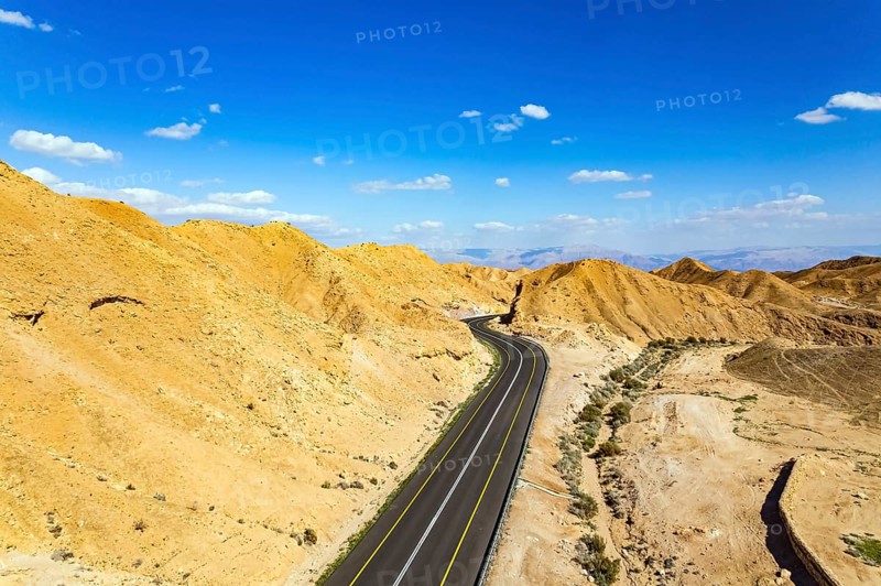 Israel. Desert on the shores of the Dead Sea. Asphalt highway meanders among the hills. Dead Sea mud has healing properties. Bird's eye view