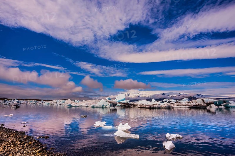 The concept of northern extreme tourism. The ice floes and cirrocumulus clouds of lagoon Jokulsarlon, Iceland