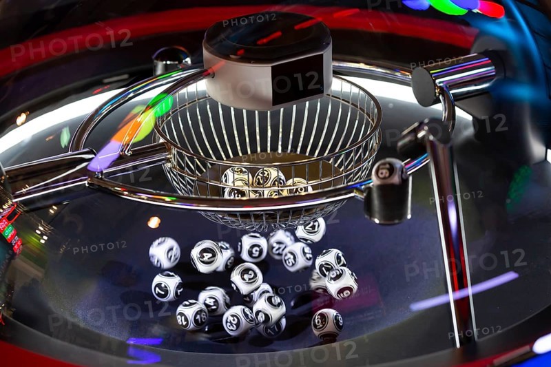 Black and white lottery balls in a rotating bingo machine. Lottery balls in a sphere in motion. Gambling machine and euqipment. Blurred lottery balls in a lotto machine. Number 16