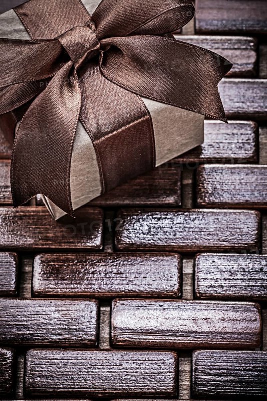Wrapped giftbox on wooden wicker matting holidays concept