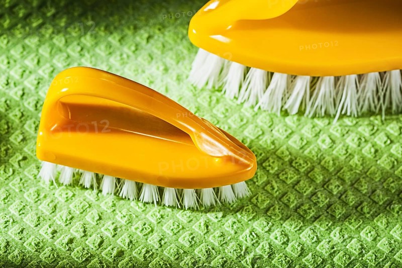 Set of new plastic brushes on green dishcloth