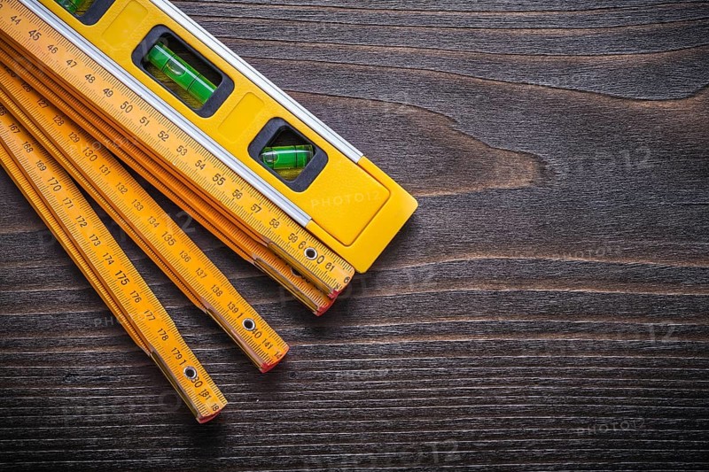 Set of yellow construction level with wooden meter on vintage wood board maintenance concept