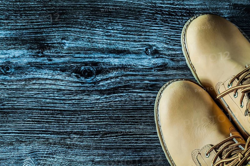 Pair of safety boots on vintage wooden board