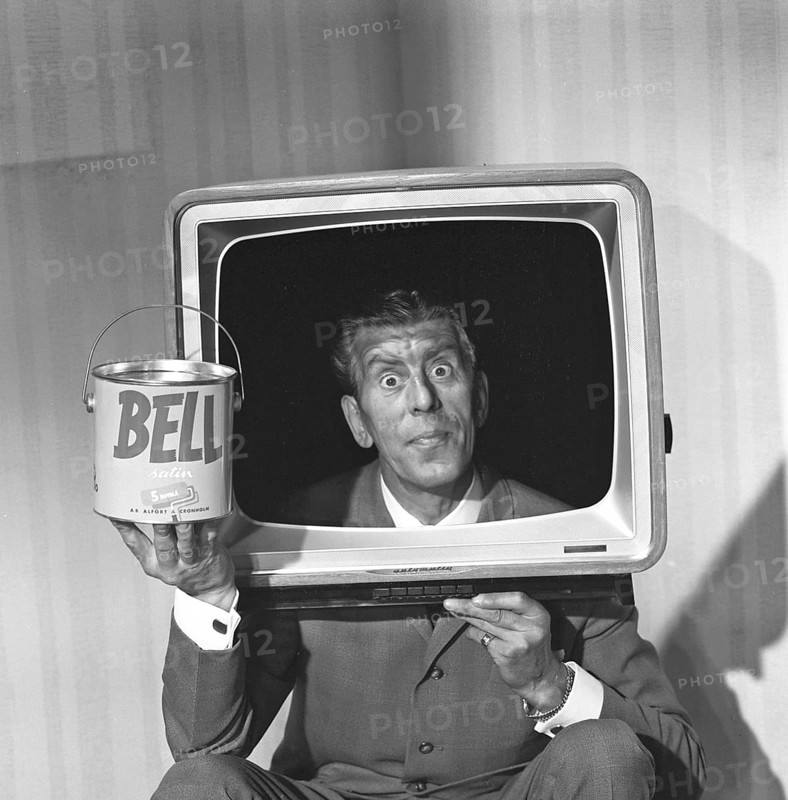 Television in the 1950s. A man wearing a televison set over his head, with the screen taken out, his face fits perfectly in the middle. He is actor Martin Ljung, hired by Alcro paint manufacturer to promote the new line of Bell latex paint. Photo Kristoffersson ref DC10-2. Sweden 1961