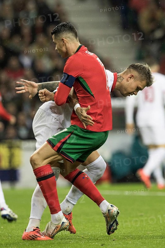 Football match, captain Cristiano RONALDO CR7 Portugal right, looking from the side in a duel with Kamil PIATKOWSKI Poland, holding and pulling each other by the jersey, Cristiano RONALDO Portugal steps with his left foot on the left foot of his opponent, Estadio do Dragao, Porto, Portugal