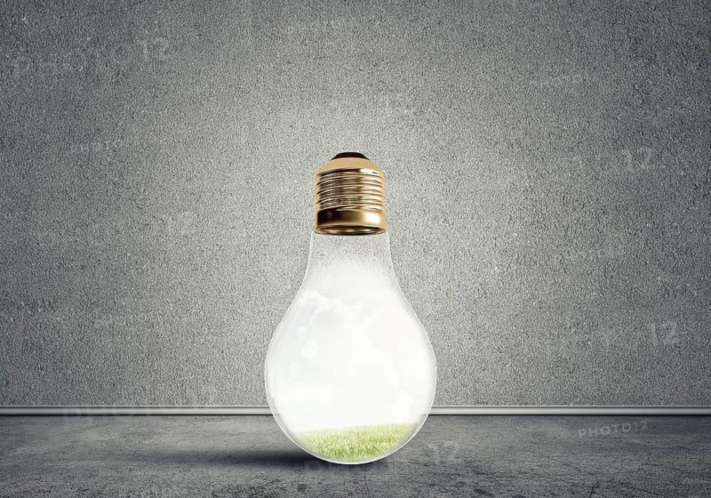 Glass light bulb in concrete empty room. Eco concept